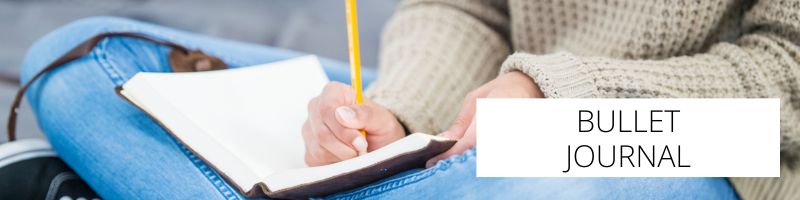 header image of a woman writing in a bullet journal