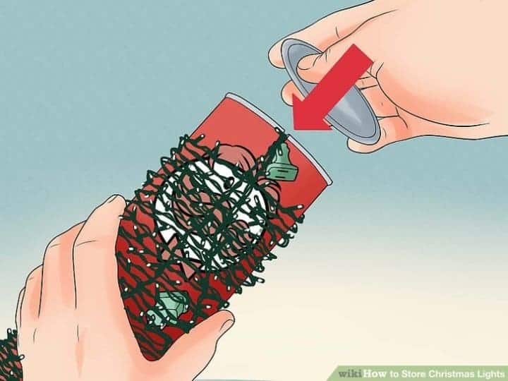using a pringles can to wrap up your christmas lights as a holiday decoration storage idea
