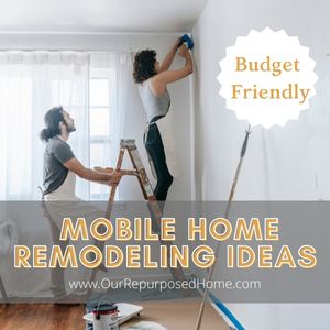 couple painting a mobile home wall