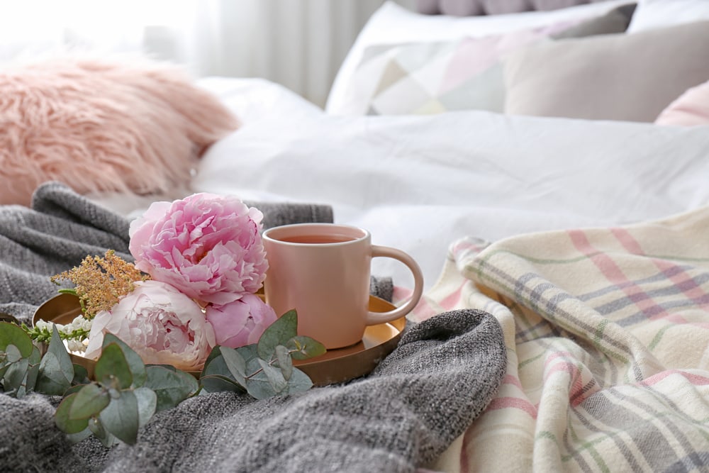 cozy bed with blankets and coffee for creating a cozy and welcoming guest room