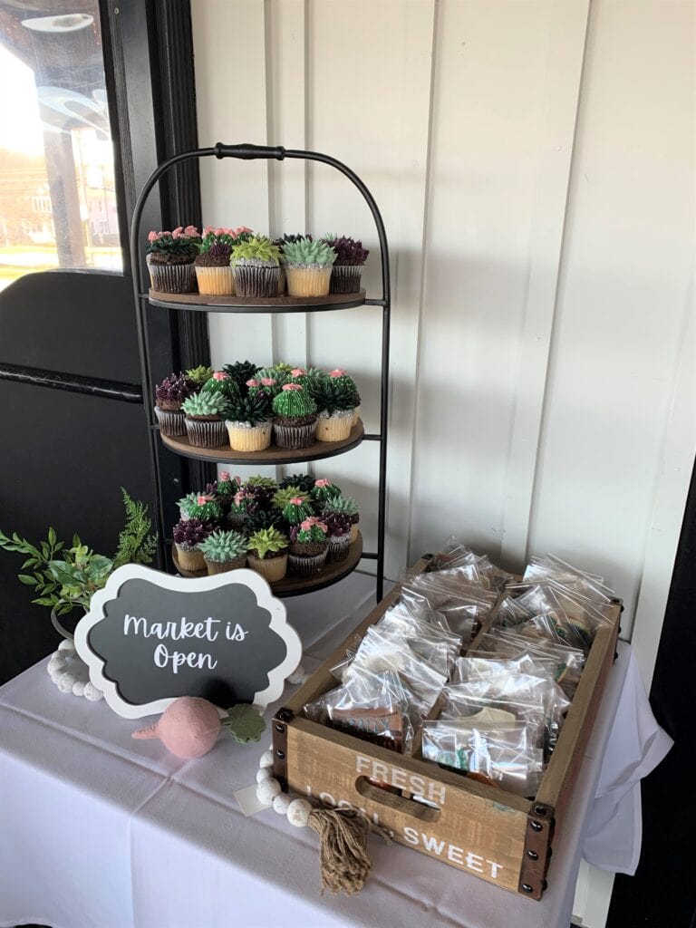 Garden themed baby shower cookies and cupcake display